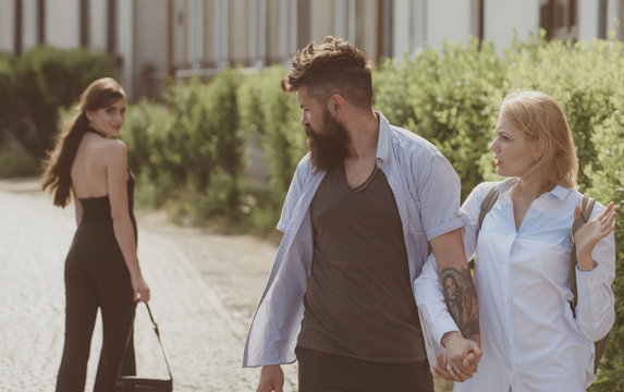 Ladies man. Bearded man looking at other girl. Hipster choosing between two women. Love triangle and threesome. Man cheating his wife or girlfriend. Betrayal and infidelity. Unfaithful love