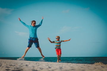 father and son have fun jump at tropical beach