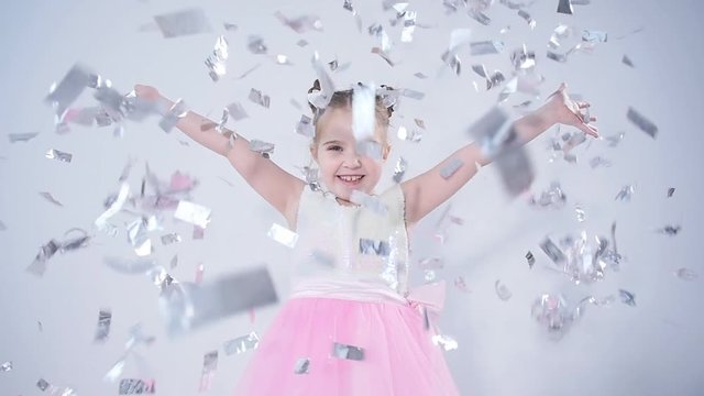 Concept of holiday and party. Happy little girl throwing confetti