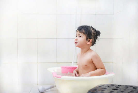 Children shower bathroom / Asia kid girl taking a bath playing - little girl 2-3 years old bathes in a shower