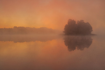 Naklejka premium Foggy morning landscape. Sunrise lake.