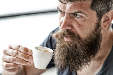 Enjoy hot drink. Hipster drinking coffee outdoor. Man with beard and mustache and cup of coffee. Bearded guy relaxing at cafe terrace. Guy relaxing with espresso coffee. Coffee break concept