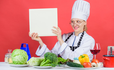 Culinary school concept. Female in hat and apron knows everything about culinary arts. Traditional cuisine. Culinary expert. Woman chef cooking healthy food. Girl read book top best culinary recipes
