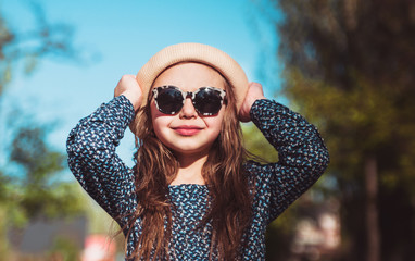 Smiling cute girl in hat posing outdoor.
