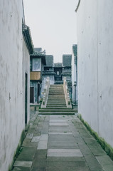 Path leading to bridge between traditional Chinese black and white houses, in downtown Jiaxing, China