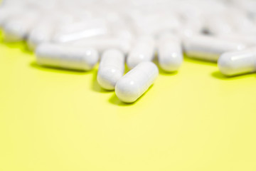 white pills on yellow background