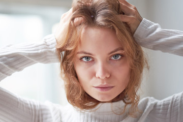 Fototapeta premium portrait of a beautiful curly girl. the mysterious face of a woman at the window.