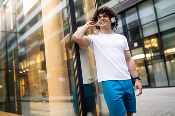 Young fit man listening to music and rest after a workout.
