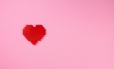 One red heart from the designer details on a pink background, lightness and romance for Valentines day, love art concept