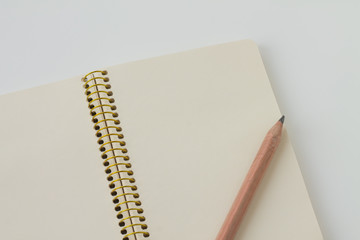 Business isolate, a notebook with a spiral on a white table and ground wooden pencil