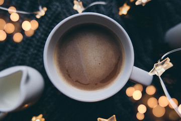Cup of coffee close up with bokeh lights.