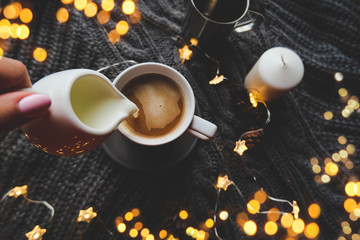 Obraz na płótnie Canvas cup of coffee with milk and star christmas garland