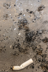 Close up cigarette and ash on the floor.