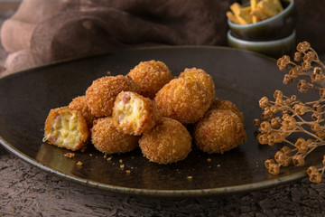 Fried potatoes balls with meat on black background. Snack to beer. Fast food.