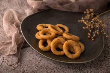Rings of onions or squid in batter on black background. Snack to beer. Snack to beer. Fast food.