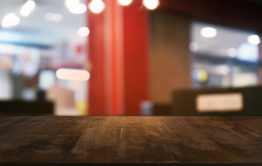 Empty dark wooden table in front of abstract blurred bokeh background of restaurant . can be used for display or montage your products.Mock up for space.