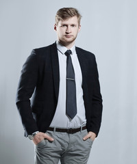 Fototapeta premium creative business man stands with his hands in his pockets.isolated on grey background