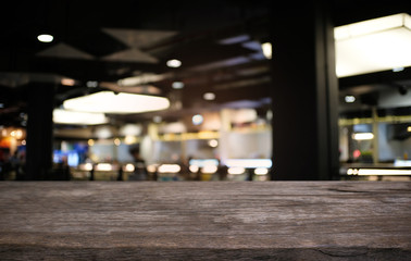 Empty wood table top and blur of night market background/selective focus .For montage product display.