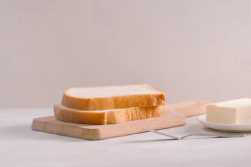 Sliced bread bake and butter on wooden cutting board. Simple breakfast