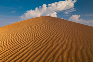 Cloudy sky over sand dunes in the desert