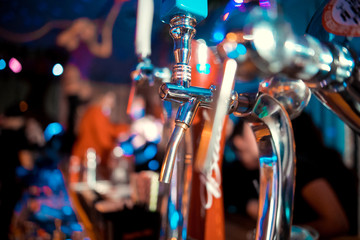 Hand of bartender pouring a large lager beer in tap. Soft, vintage instagram effect on photo. Pouring beer for client. Side view of young bartender pouring beer while standing at the bar counter