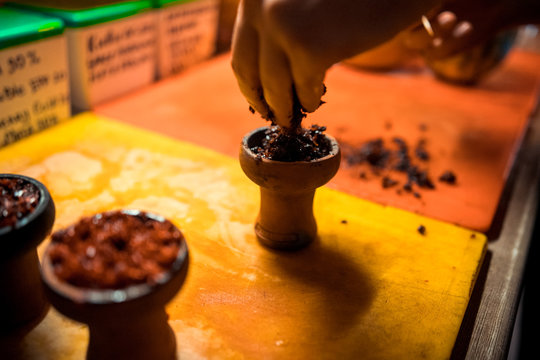 A man prepare hookah sisha in hookah art bar. Tabaco preparation.