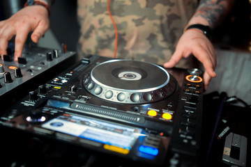 Obraz premium Dj mixes the track in the nightclub at a party. In the background laser light show