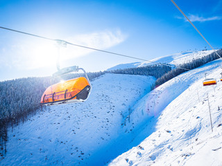 ski lift in mountains into sunflares