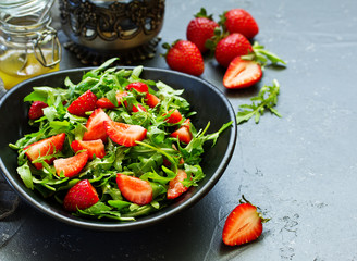 Fresh salad with arugula, strawberries and almonds. Selective focus.