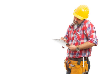 Builder taking notes as talking on phone.