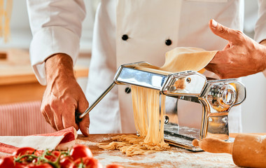 Chef cutting fresh homemade pasta noodles