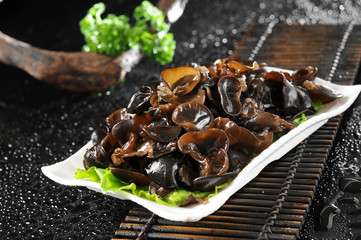 Fresh black agaric in a ceramic dish
