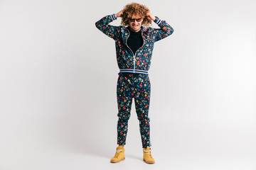 Fototapeta premium Adult shylish man in fashion clothes, yellow sneakers posing on white studio background. Excited bizarre crazy shocked male shouting, tearing hair. Surprised funny happy young brazilian guy screaming.