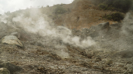plateau with geothermal volcanic activity, geysers. volcanic landscape Dieng Plateau, Indonesia. Famous tourist destination of Sikidang Crater it still generates thick sulfur fumes.