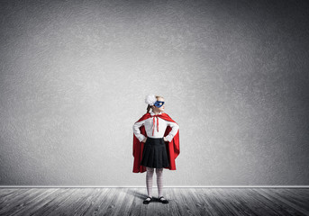 Girl power concept with cute kid guardian in empty room. Mixed m