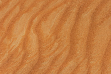 The design of the rippling textured sand dunes background in the beautiful sunshine in the United Arab Emirates.