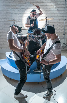Musicians play guitars and drums