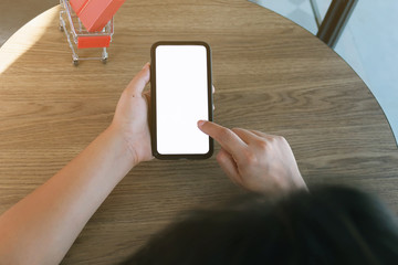 Woman and Small shopping cart with smartphone for Internet online shopping concept.