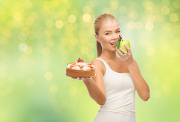 slimming and diet concept - happy woman eating apple instead of cake over summer green lights background