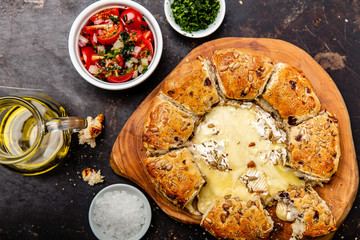 Camembert baked in the oven with herb bread served with tomato salad