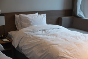 Pillow on bed in white hotel bedroom