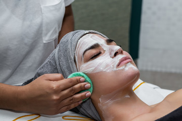 Woman removing mask from face of client