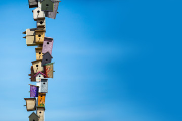 Many birdhouses over blue sky background