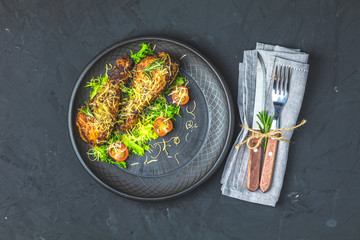 Baked chicken drumstick in a black ceramic plate