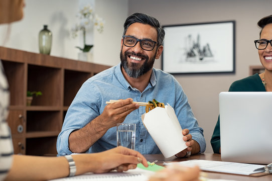 Businessman eating noodles during lunch break