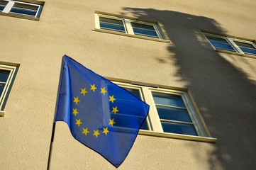 Flaga Unii Europejskiej na tle budynku - obrazy, fototapety, plakaty