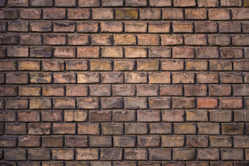Wall made from red and sometimes colorful bricks of regular shapes and random distribution slotting together precisely. Close up architecture photography. Creative wallpaper photography.