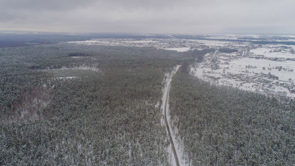 Aiereal wives of the road in winter forest with lot of trees and snow , drone shoot ,Ukraine 