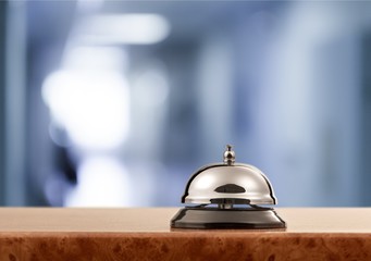 Vintage hotel reception service desk bell on blurred background