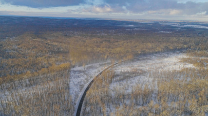 Aiereal wives of the road in winter forest with lot of trees and snow , drone shoot ,Ukraine 